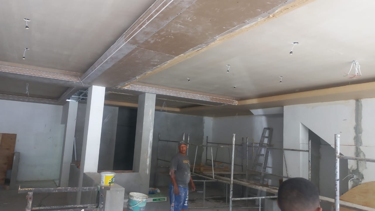 Commercial interior under construction with ceiling panels, bulkheads and scaffolding