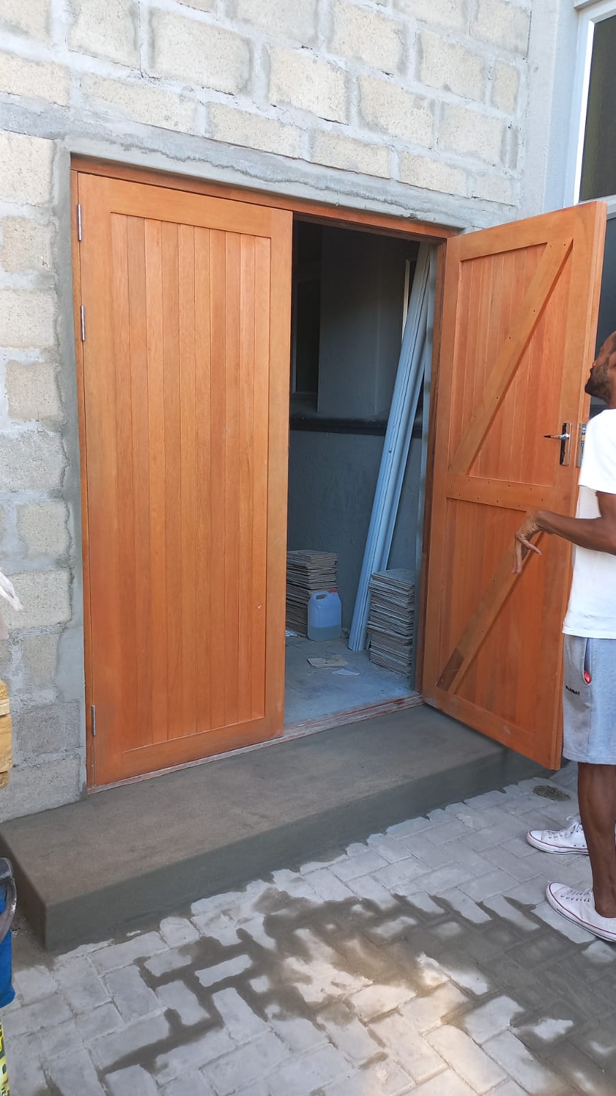 Timber double doors installed in a stone wall with a newly formed entrance step
