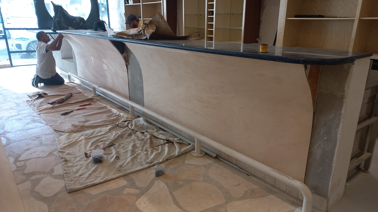Workers fitting timber panels to an entertainment bar counter