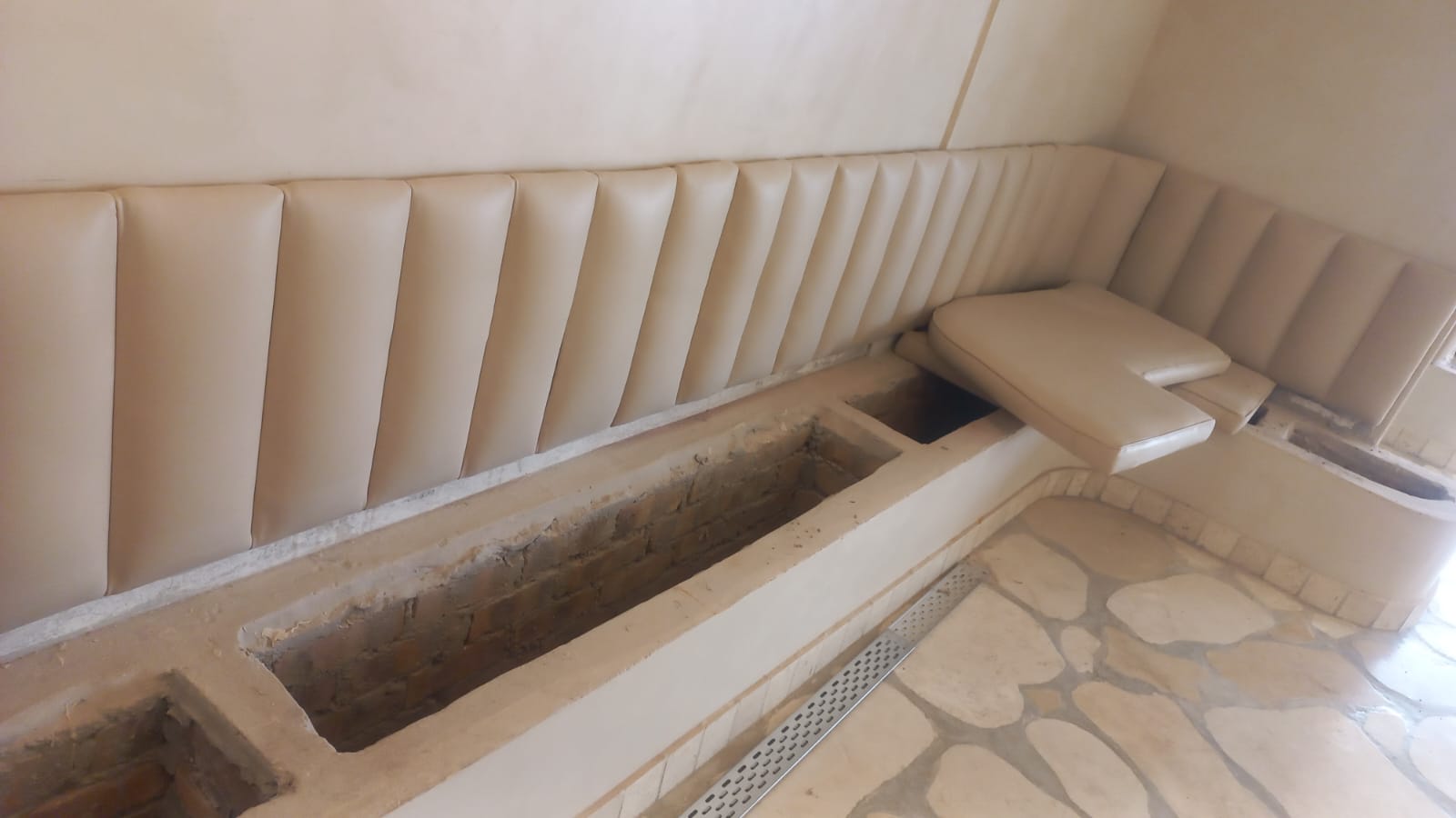 Built-in upholstered seating with open masonry bases during installation