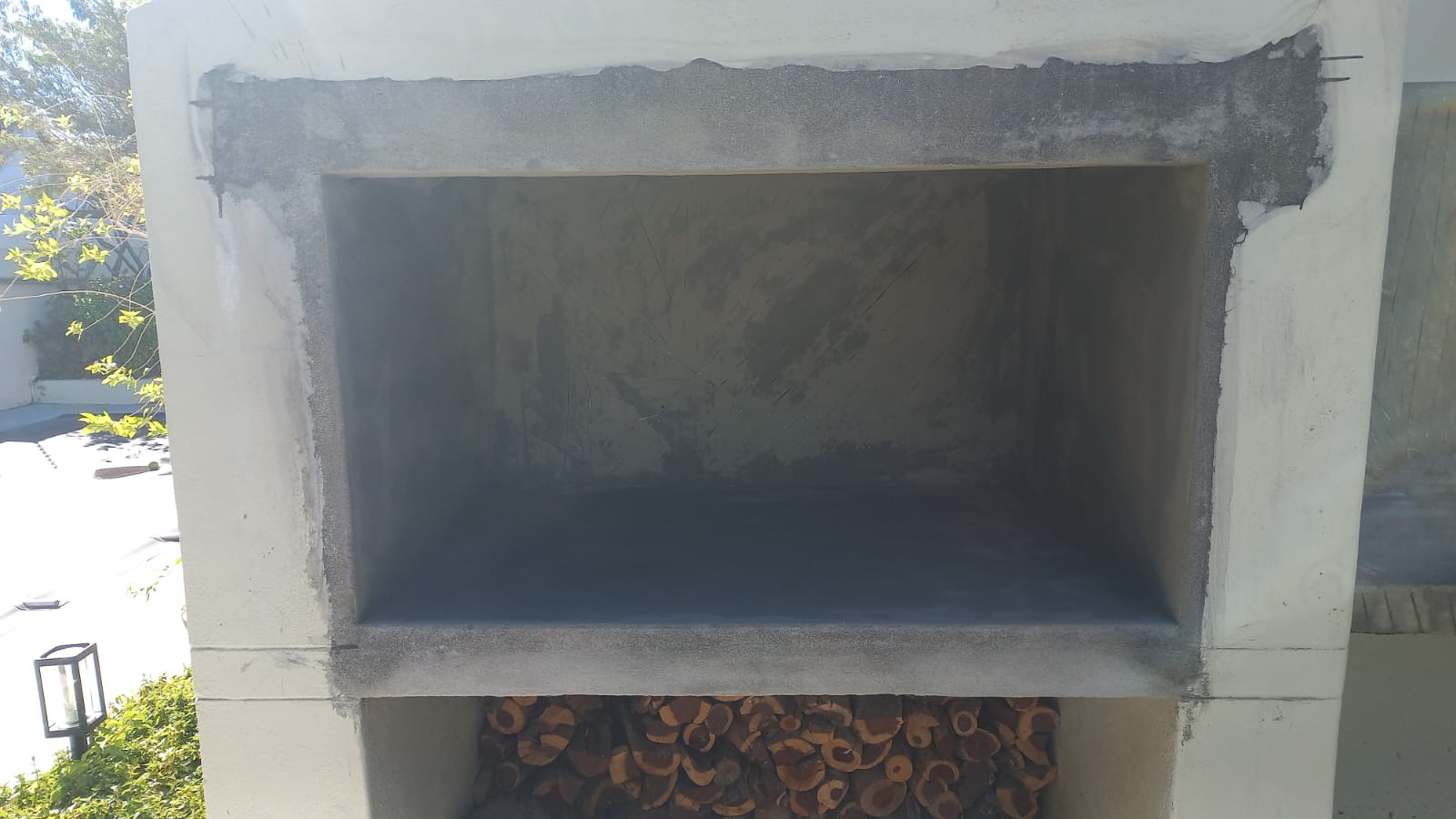 Built-in braai with a prepared masonry surround and firewood storage beneath