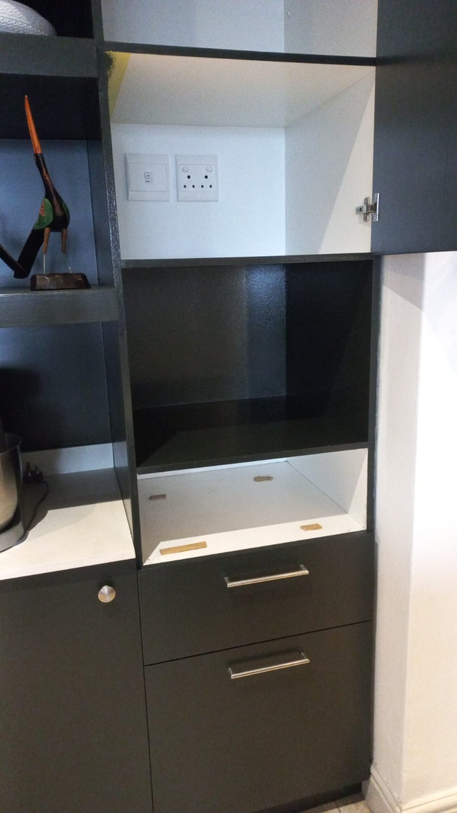 Dark cabinetry with open shelves, cupboard doors and drawers