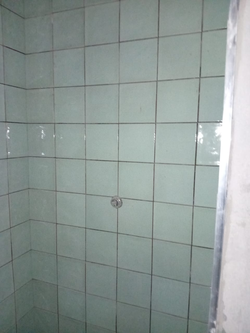 Tiled shower walls with an exposed fitting point during installation