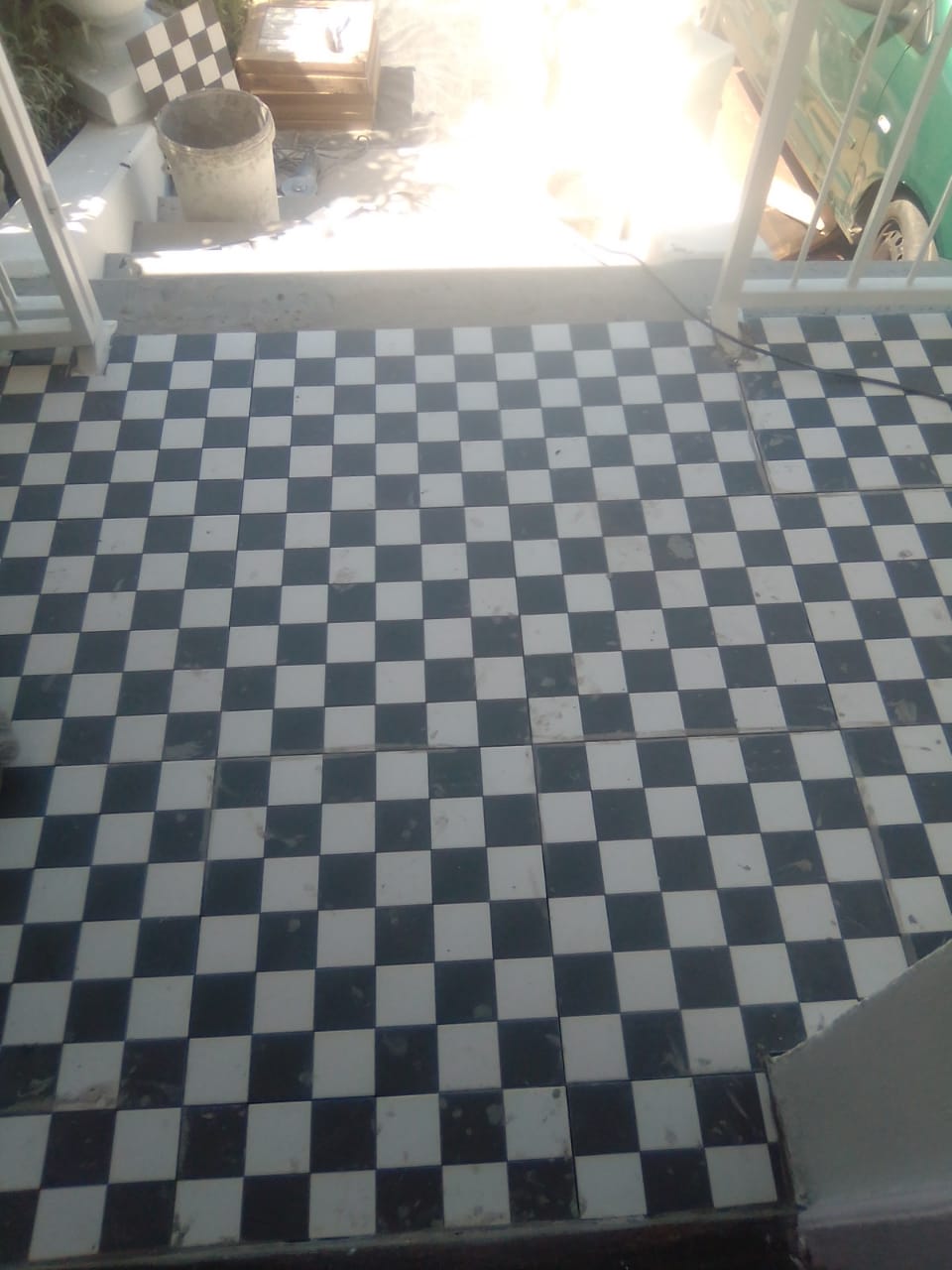 Black-and-white checkerboard floor tiles with work materials nearby