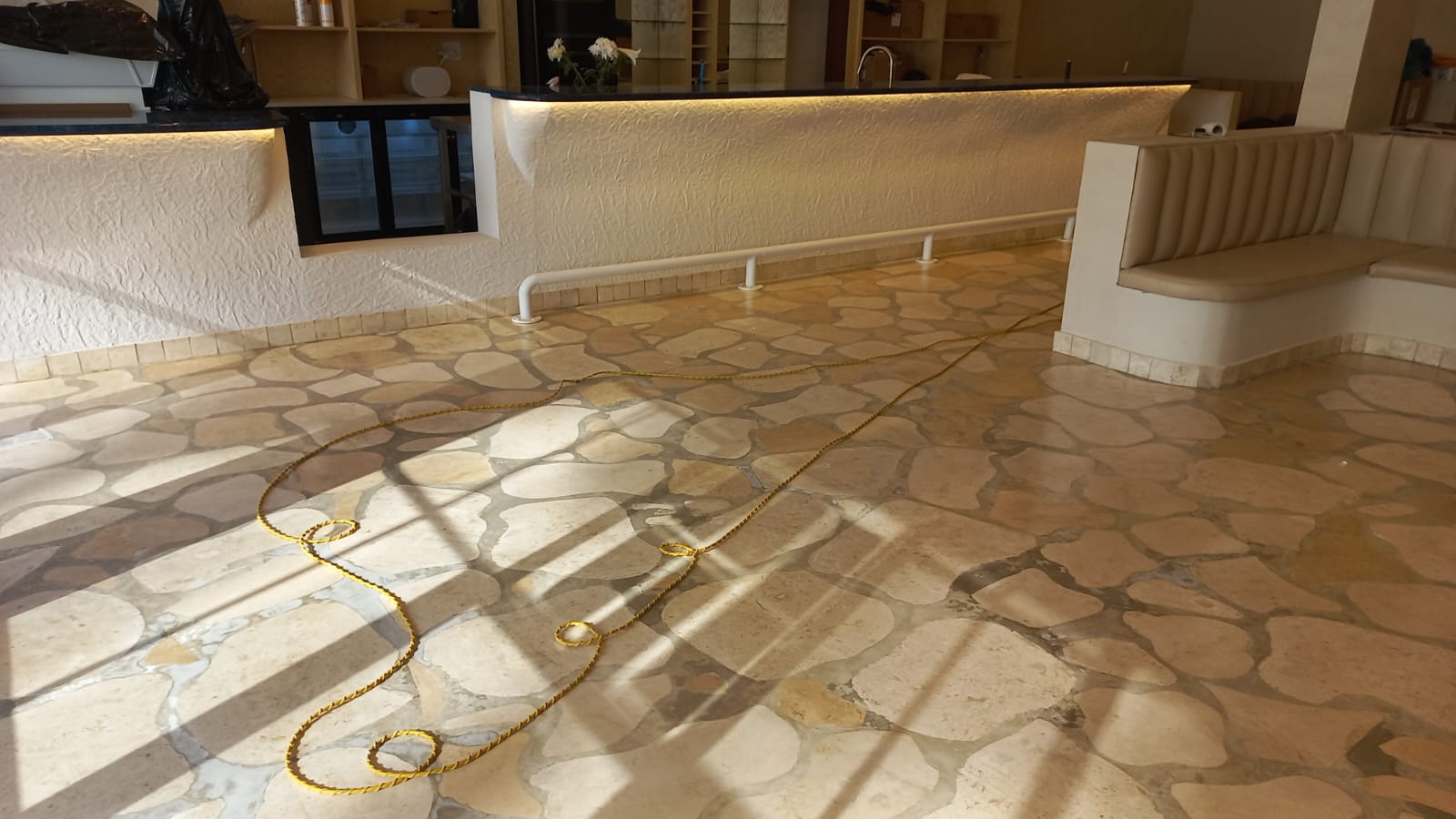 Irregular stone floor with a bar counter, built-in seating and a cable during fit-out